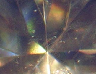 To identify moissanite, look through the stone and note how the facet edges appear doubled
